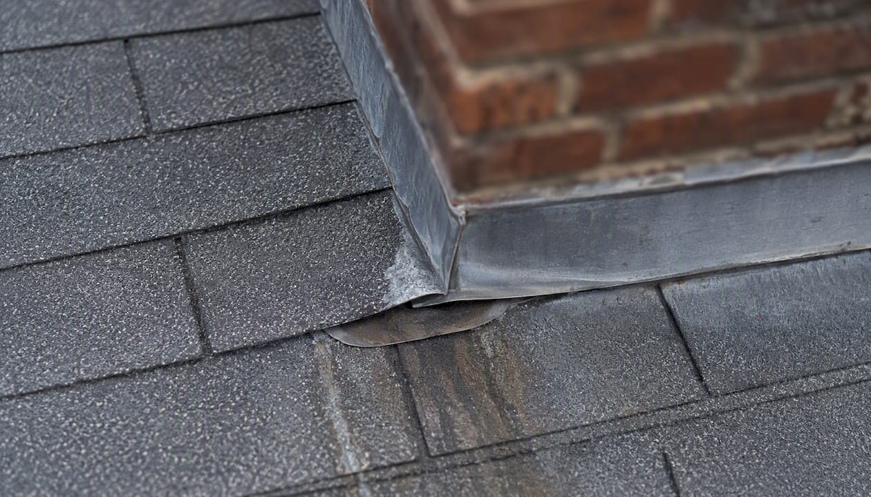 Close-up of chimney flashing on roof with water marks