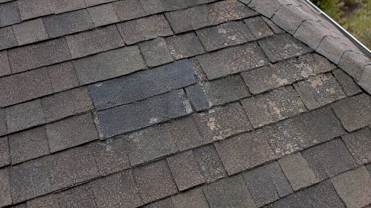Weathered shingles with an older repair patch